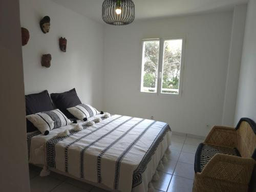 une chambre avec un lit, une fenêtre et une chaise dans l'établissement Les Saquedes 48, à Sainte-Maxime