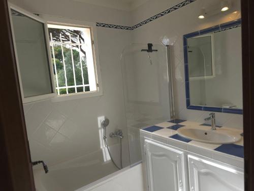 une salle de bain blanche avec un lavabo et une douche dans l'établissement Les Saquedes 48, à Sainte-Maxime