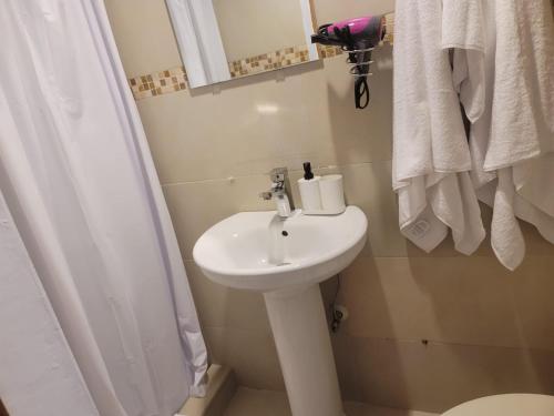 a bathroom with a white sink and a shower at small apartment in Santo Domingo
