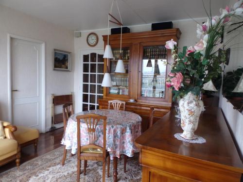 une salle à manger avec une table et un vase de fleurs dans l'établissement Sweet Home Panoramique Sacré Coeur, à Paris