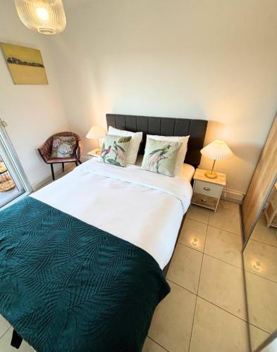 une chambre avec un grand lit avec une couverture verte dans l'établissement Charmant T2 à 10 min de Cannes, au Cannet