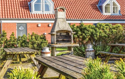 a picnic table with an outdoor oven in a yard at 2 Bedroom Lovely Apartment In Lemvig in Lemvig