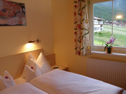 1 dormitorio con 2 camas blancas y ventana en Appartement Arnika, en Sölden