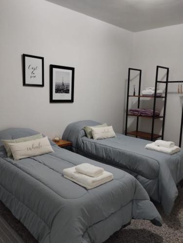 two beds in a room with towels on them at Departamento en el centro de General Pico in General Pico