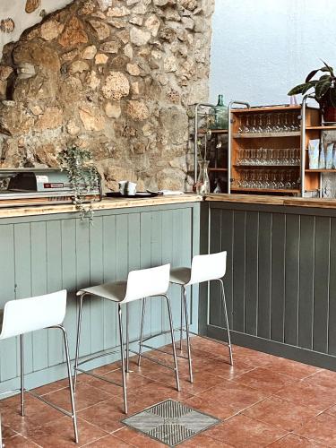 a kitchen with a table and white chairs in front of a counter at Alberg rural torre del baró in Sant Llorenc de Morunys