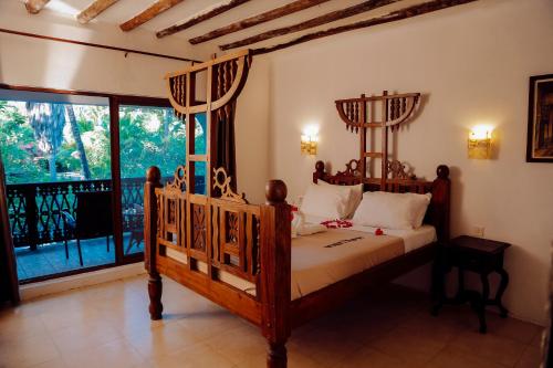 a bedroom with a bed and a large window at Langi Langi Beach Bungalows in Nungwi