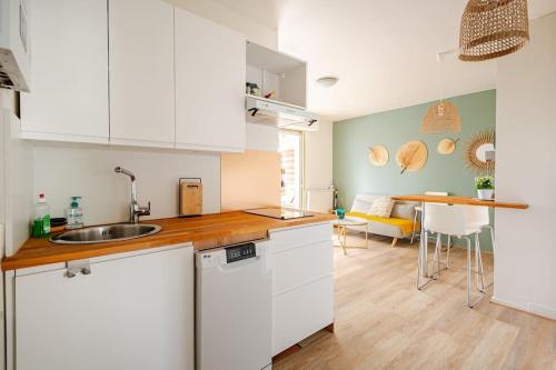 une cuisine avec des placards blancs et une salle à manger dans l'établissement Studio ensoleillé port Bassin d'Arcachon, à Arcachon