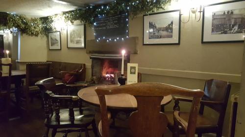 a restaurant with a table and chairs and a fireplace at The Cavendish Arms in Cartmel