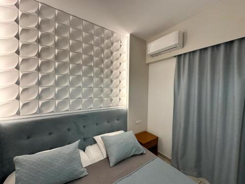 a bedroom with a headboard and a bed with pillows at Castro Hotel in Amoudara Herakliou