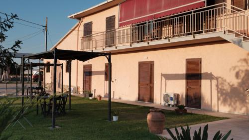 a building with a balcony and a yard with a fire hydrant at Agriturismo da Michele e Carmela di Voli Patrizia in Donoratico