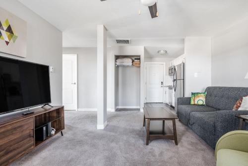 a living room with a couch and a tv at Spacious 2BR Apt on Mass Ave w Kitchen in Indianapolis