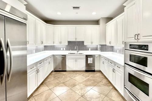 a kitchen with white cabinets and stainless steel appliances at Sandpearl Residences 606 in Clearwater Beach