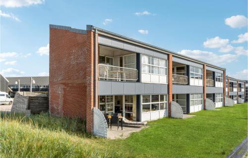 a large brick building with a grass field in front of it at Fanø Bad, Lejl 6 in Fanø