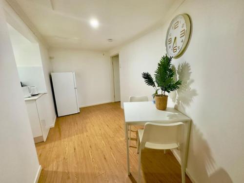 a dining room with a table and a clock on the wall at Prime 1BR Near Transport and Retail in Brisbane