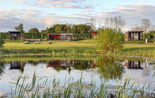 a house by a pond with houses in the background at Chalet 21 Am See in Süsel