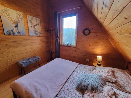 a bedroom with a bed in a log cabin at Chatka Beskidzka in Targanice