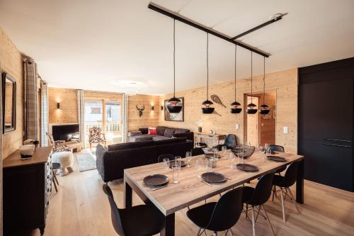 - un salon avec une grande table et des chaises en bois dans l'établissement Appartement Margot - All the comforts with a view of Mont Blanc, à Combloux