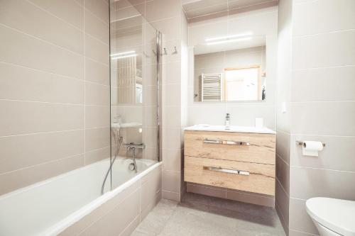 une salle de bain avec une baignoire, un lavabo et des toilettes dans l'établissement Appartement Margot - All the comforts with a view of Mont Blanc, à Combloux