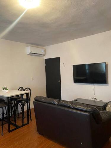 a living room with a black couch and a table at Departamento acogedor segundo piso 2 recamaras in Monterrey