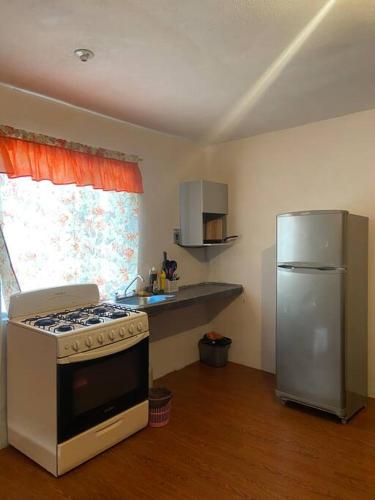 a kitchen with a stove and a refrigerator at Departamento acogedor segundo piso 2 recamaras in Monterrey