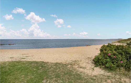 ein Sandstrand mit rosa Blumen und dem Meer in der Unterkunft Holiday Home Fasanvænget Hemmet I in Hemmet