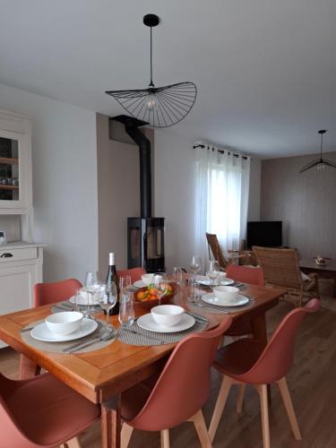 une salle à manger avec une table en bois et des chaises rouges dans l'établissement Ty Gwenn, à La Baule