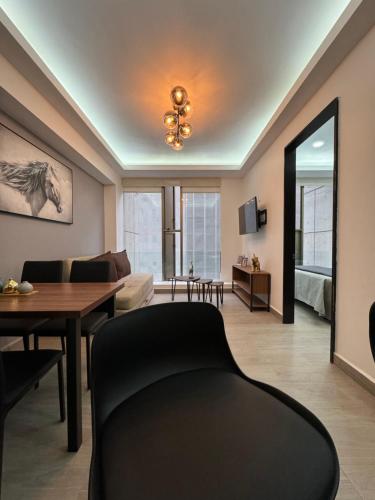 a living room with a black chair and a table at Departamento Elefante in Mexico City
