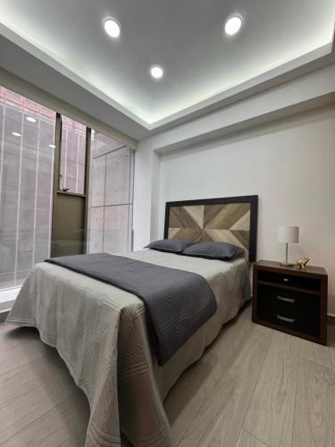 a bedroom with a large bed and a window at Departamento Elefante in Mexico City