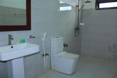a bathroom with a sink and a toilet and a shower at CPS Lihini Beach Hotel in Induruwa