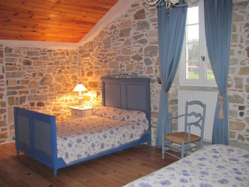 um quarto com 2 camas e uma parede de pedra em Chambres d'Hôtes Gelous em Bidache