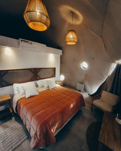 ein Schlafzimmer mit einem Bett und zwei Lampen in der Unterkunft Desert Camp in Fiambala