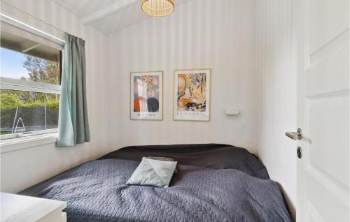a bedroom with a bed and two pictures on the wall at Stunning Home In Græsted With Wifi in Græsted