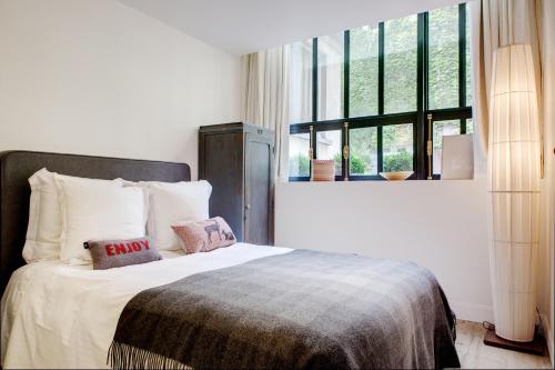 une chambre avec un lit avec des oreillers et une fenêtre dans l'établissement Paris Green House residence, à Paris