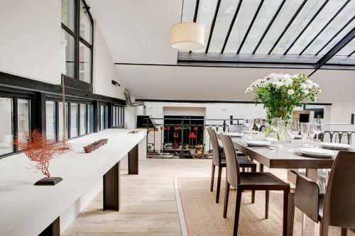 une salle à manger avec une longue table et des chaises dans l'établissement Paris Green House residence, à Paris