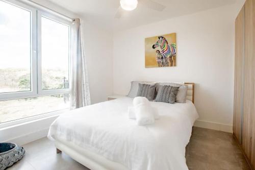 a white bed in a white bedroom with a window at Spacious Bright & Airy Penthouse C at Playa Venao in Playa Venao