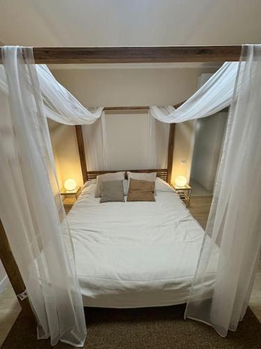 a bedroom with a canopy bed with white curtains at Appartamenti a Carpi in Carpi