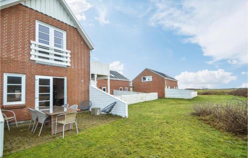 a brick house with a table and chairs in the yard at 2 Bedroom Amazing Apartment In Rømø in Sønderby