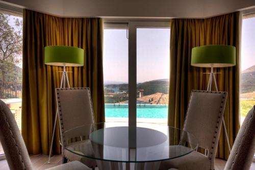 a dining room with a glass table and two lamps at Salvator Villas & Spa Hotel in Parga