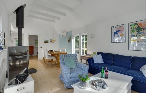 a living room with a blue couch and a table at 2 Bedroom Beautiful Home In Nykøbing Sj in Nykøbing Sjælland