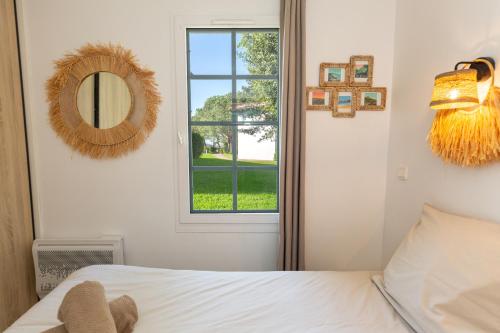 une chambre avec un lit, un miroir et une fenêtre dans l'établissement Atlantic Selection - Domaine de Bordaberry - Jardin & superbe piscine, à Urrugne