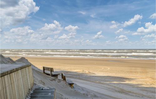 a beach with a wooden fence and the ocean at Holiday Home Solbærvangen Sun in Ovtrup