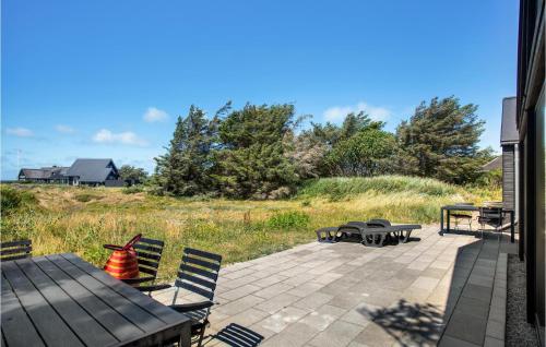 a patio with a table and chairs and a picnic table at Lovely Home In Blokhus With Sauna in Blokhus