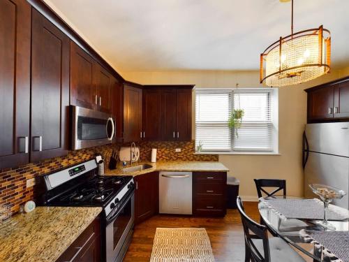 a kitchen with wooden cabinets and a stove top oven at Chi-Town Hideout #1 in Berwyn