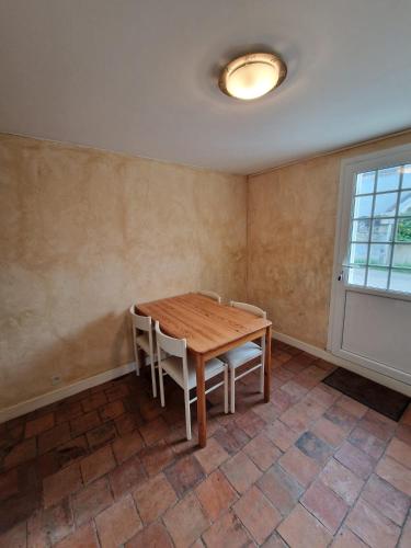 une salle à manger avec une table et des chaises en bois dans l'établissement Appartement proche St Emilion, à Vignonet