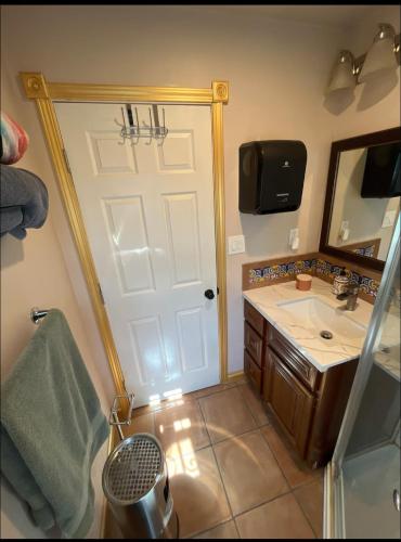 a bathroom with a white door and a sink at Charming Casita all too yourself near Midtown, Train and Freeway in Sacramento