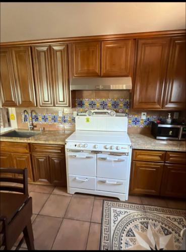a white stove in a kitchen with wooden cabinets at Charming Casita all too yourself near Midtown, Train and Freeway in Sacramento