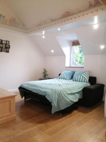 une chambre avec un lit avec une couette bleue dans l'établissement En pleine verdure, à Glaignes