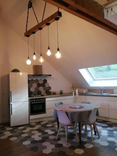 une cuisine avec une table et un réfrigérateur blanc dans l'établissement En pleine verdure, à Glaignes