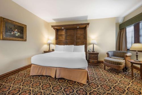 a bedroom with a large bed and a chair at Best Western Premier Mariemont Inn in Cincinnati
