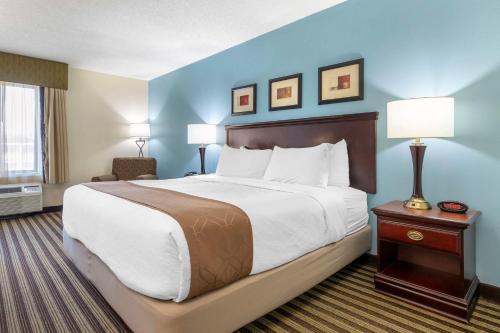 a large bed in a hotel room with blue walls at Best Western Plus Sikeston in Sikeston